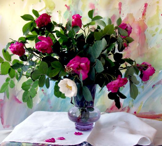 Róże w szklanym wazonie na białym obrusie